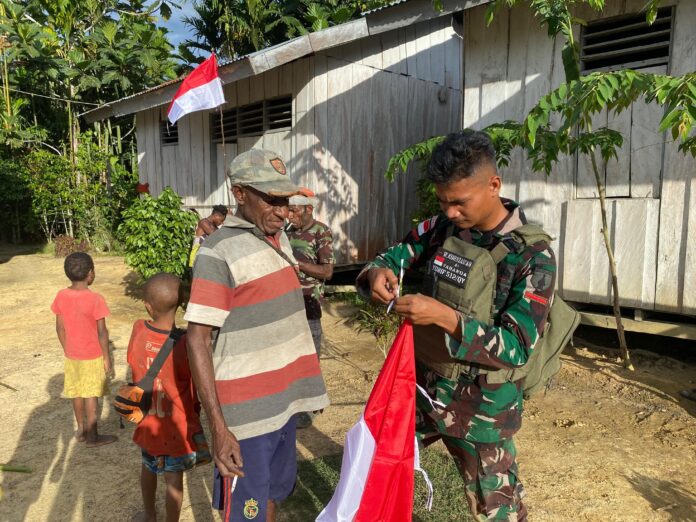 Bangkitkan Jiwa Nasionalisme, Satgas Yonif 512_QY Bersama Masyarakat Yabanda Kibarkan Bendera Merah Putih di Rumah-rumah Warga