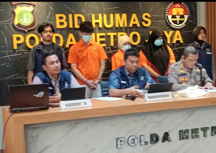 Wadirressiber Polda Metro Jaya AKBP Fian Yunus (tengah) dengan latar belakang tiga pelaku